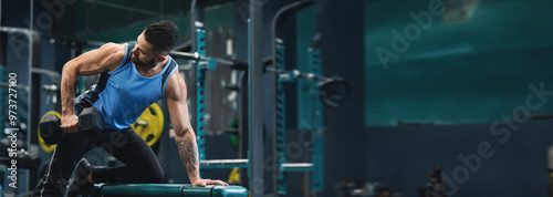 A man performs a strength training exercise with a dumbbell at a gym, focusing on building muscle and improving fitness, copy space photo