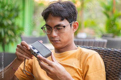 Young Man Examining Vintage Camera Outdoors