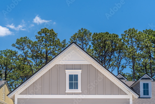 Gable with grey horizontal vinyl lap siding, double hung window with white frame, vinyl shutters on a pitched roof attic at a luxury American single family home neighborhood USA	 photo