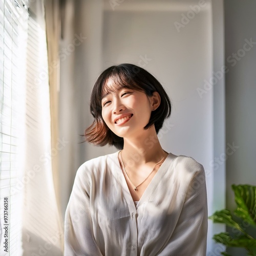 Free Download A radiant young Japanese woman with short hair basks in the gentle morning sun, her serene smile glowing in natural light, capturing a moment of joy and tranquility. - GFXLoad