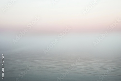 Calm sea merging with foggy sky at sunset