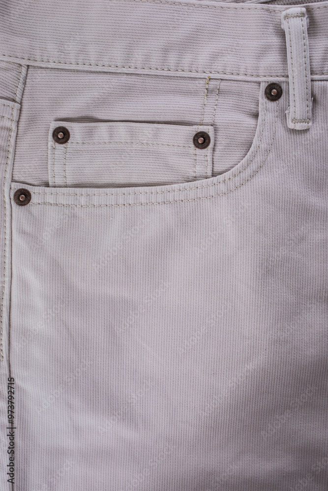 Close-up of a beige denim jeans pocket with a leather jacket detail on white background Close-up of a beige denim jeans pocket with a leather jacket detail on white background