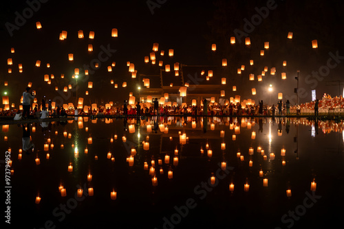 Foto Fire Lanterns Floating up into the sky is reflection in the water at night at Loi Krathong Festival Travel Destinations Of Chiang Mai, Thailand