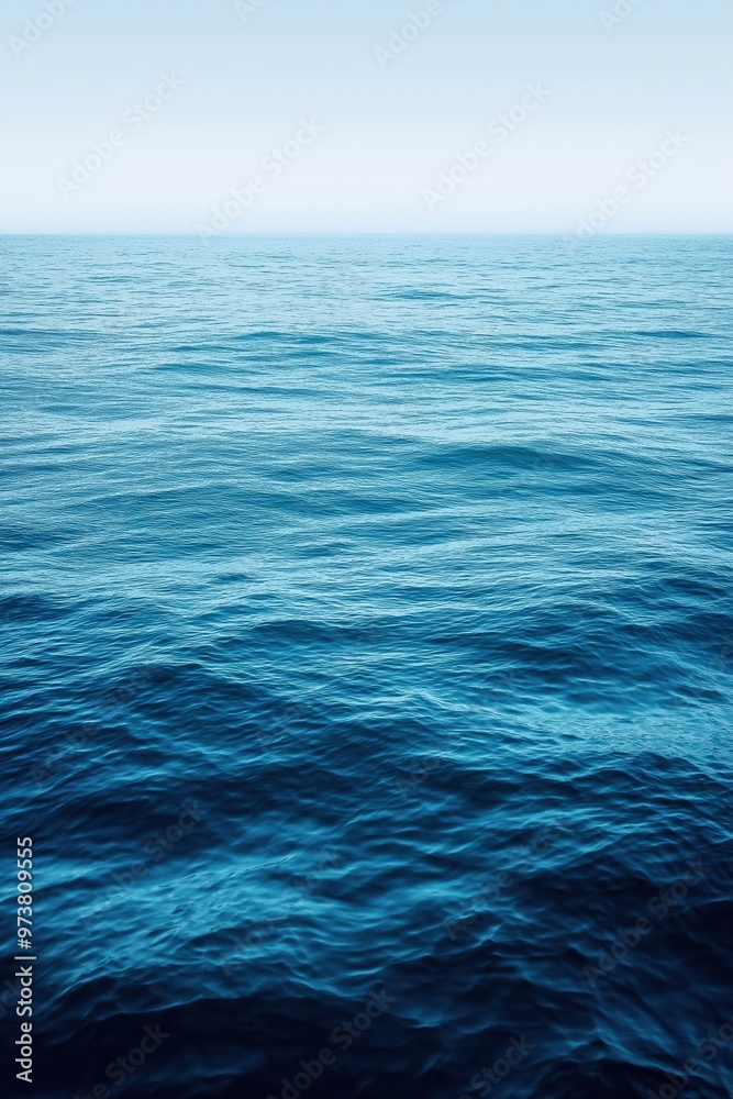 Deep blue ocean water surface merging with horizon on a misty day