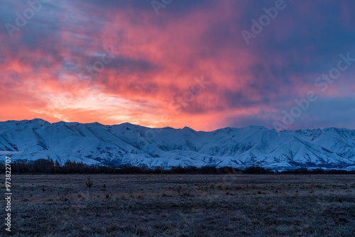 Vibrant sunset over the snow covered mountain range near Twizel photo