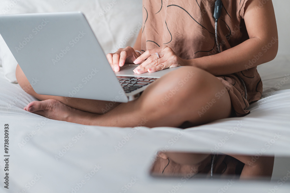 Naklejka premium Person Working on Laptop in Bed