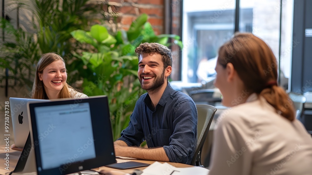 Three Smiling Coworkers Collaborating in Modern Office Three Smiling Coworkers Collaborating in Modern Office
