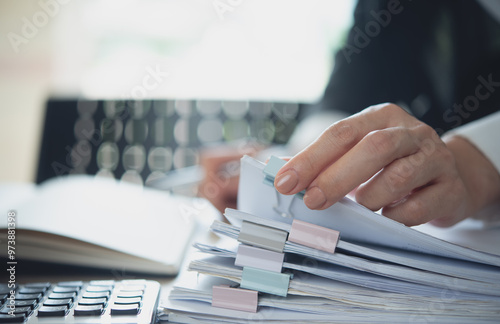 Document management. Businesswoman working with stack of paper files for searching and checking corporate files, document achieves on folders paper on office table, closeup