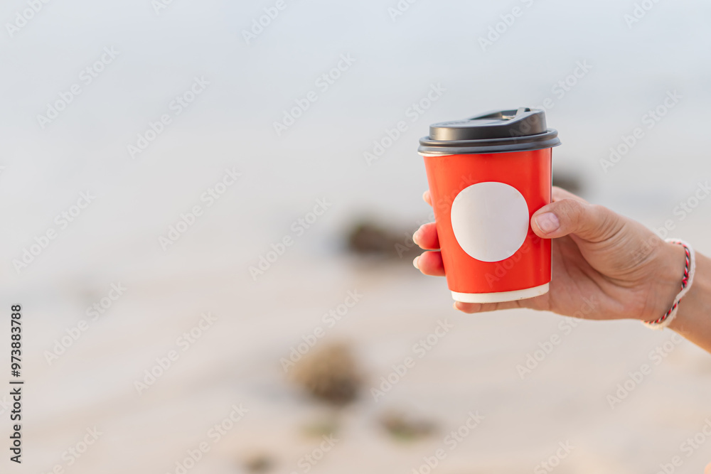 Hand Holding a Red Coffee Cup Outdoors Hand Holding a Red Coffee Cup Outdoors