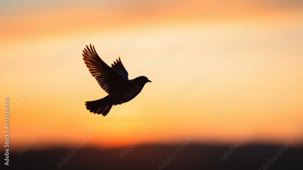 Fototapeta premium Silhouette of a Bird in Flight Against a Vibrant Sunset Sky with Orange and Yellow Hues