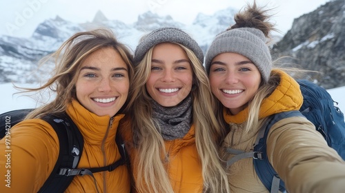 Three women smiling and taking a selfie from the back of their SUV, with a scenic mountain landscape behind them.