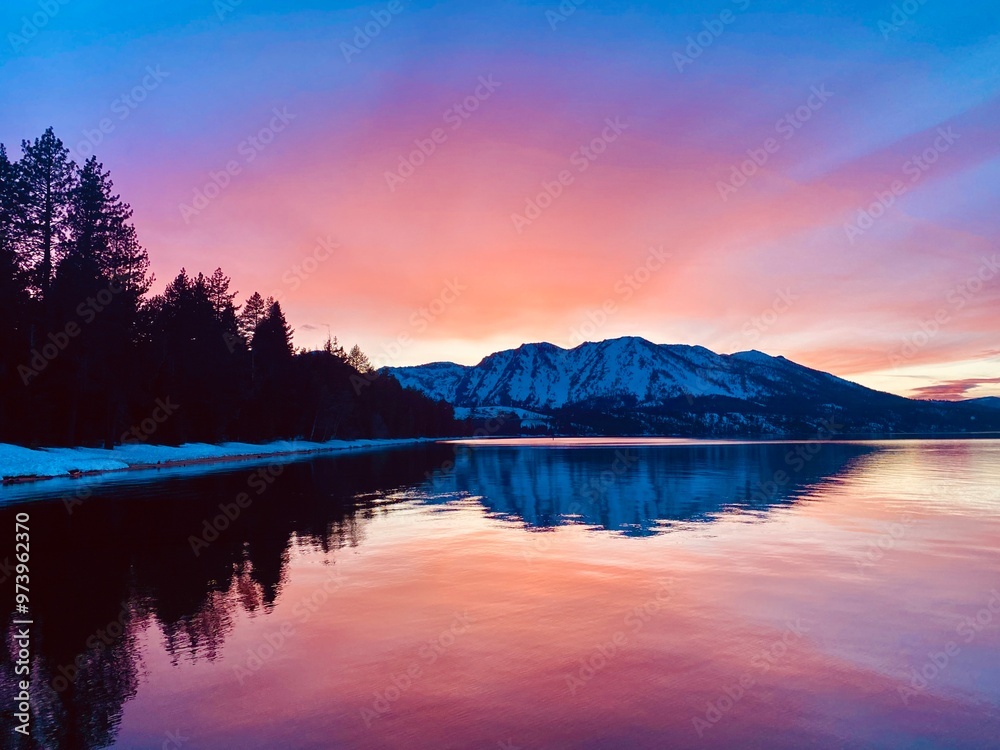 Fototapeta premium Bright pink sunset over mountains reflecting on lake tahoe