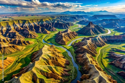 A sweeping aerial view of a rugged, mountainous landscape reveals a complex network of valleys, ridges, and serpentine photo