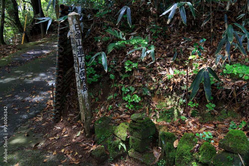 Fototapeta premium 日金山の苔むした仏塔のある小道の道標(日本、熱海市)