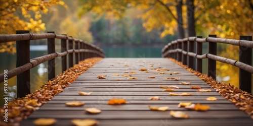 A wooden bridge over a lake with autumn leaves on the ground. photo