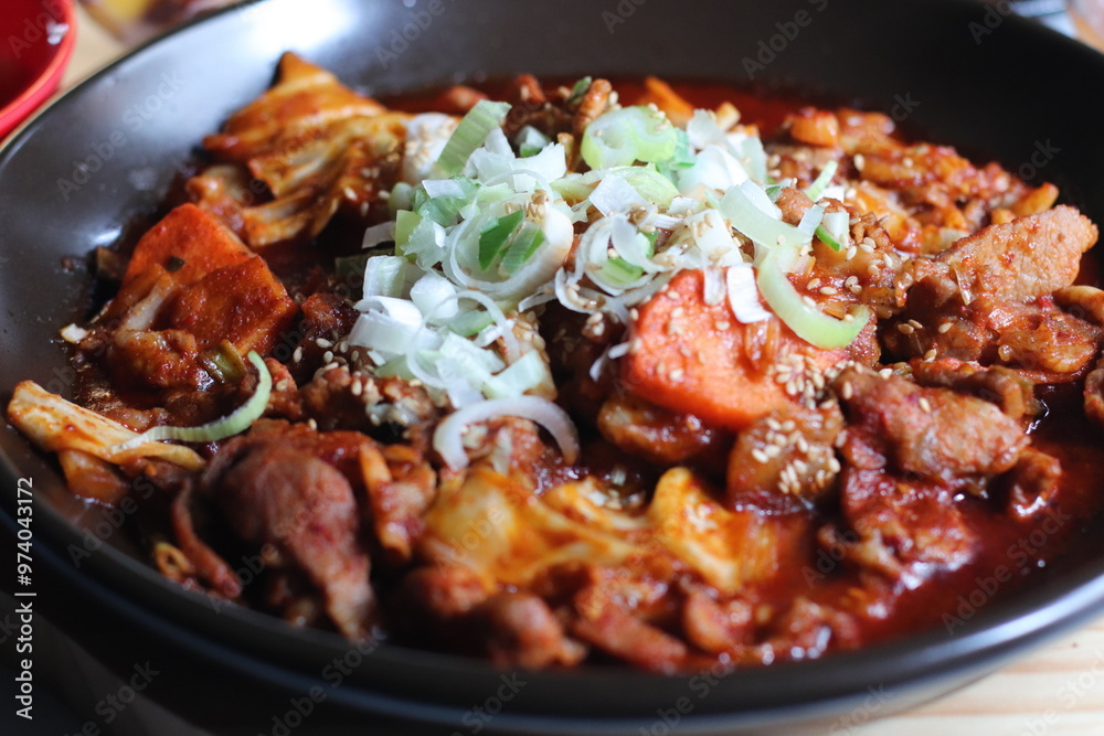 A flavorful dish of spicy stir-fried pork, coated in a rich, vibrant red sauce. The tender pork pieces are seasoned with garlic and chili paste, creating a bold and savory taste.

