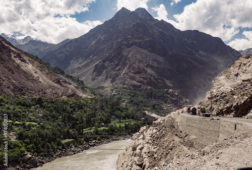 A mountain range with a river running through it and a dangerous road photo