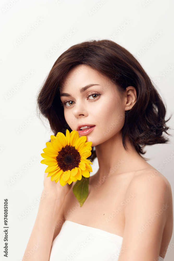 Beautiful young woman holds a sunflower on a white background Beautiful young woman holds a sunflower on a white background