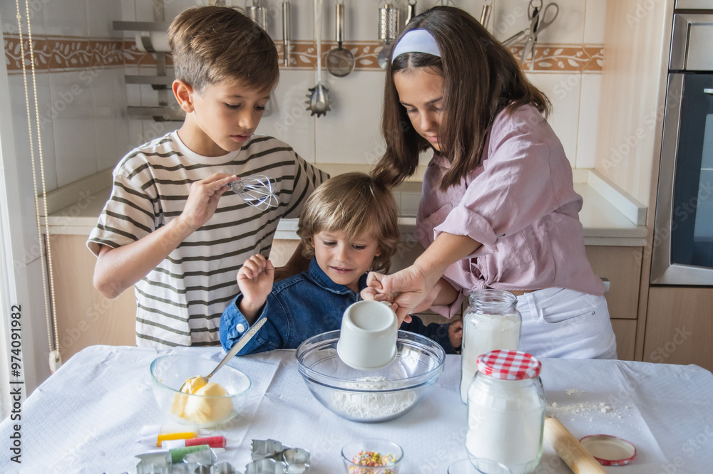 Three Happy Children In The Kitchen Adding Ingredients To Cookie Dough With Smiles And Positive Emotion As Future Little Chefs In A Family Setting Three Happy Children In The Kitchen Adding Ingredients To Cookie Dough With Smiles And Positive Emotion As Future Little Chefs In A Family Setting