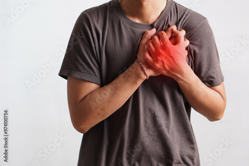 man suffering from central chest pain. Chest pain can be caused by heart attack, myocardial infarct or ischemia, myocarditis, pneumonia, oesophagitis, stress, etc,. photo