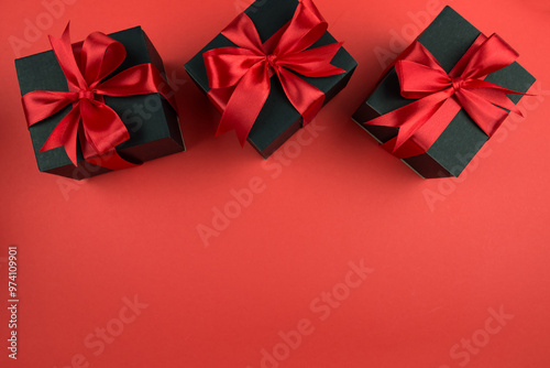 Top view photo of gift boxes with bow on isolated red background.
