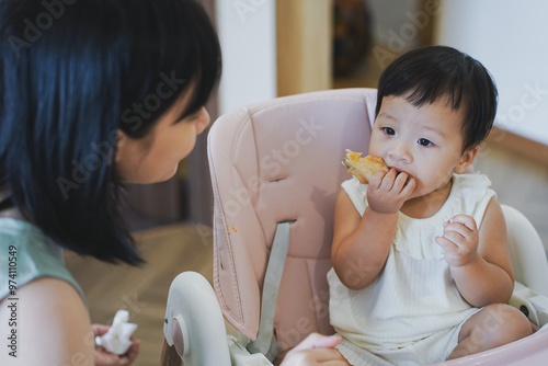 Asian woman coaxing her child to eat lunch
 photo