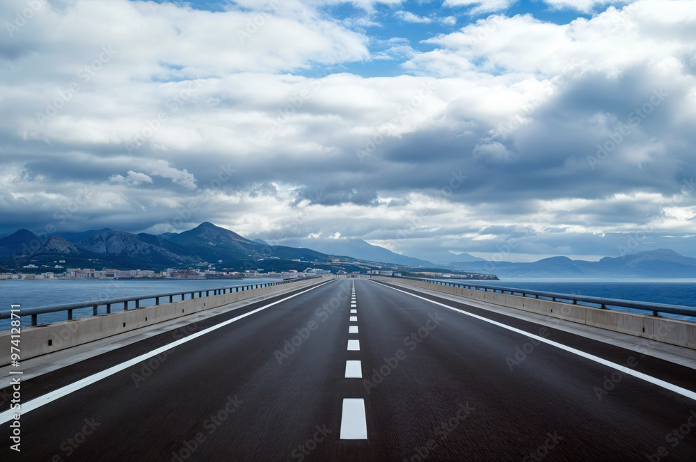 Empty highway leading to the mountains across the sea Empty highway leading to the mountains across the sea