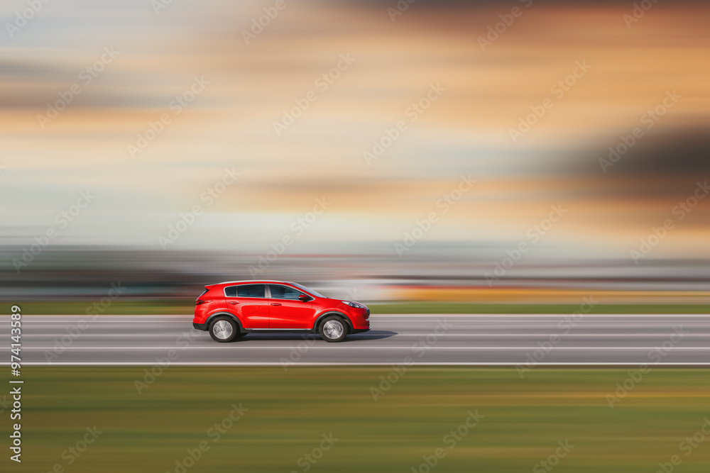 Red car. A red crossover is driving down the street at high speed. Background blurred at speed Red car. A red crossover is driving down the street at high speed. Background blurred at speed