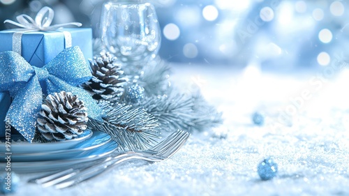 A beautifully set table with festive decorations, featuring a blue gift box, pine cones, and elegant glassware, ideal for celebrations.