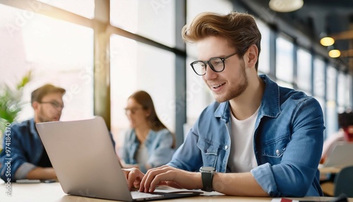 Young Man Working on Laptop in Modern Office Setting During Daytime