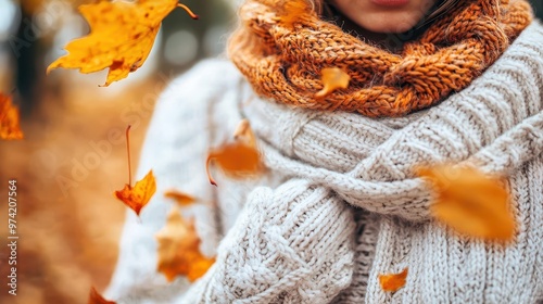 Comfy sweater weather, person wrapped in thick knitwear with autumn leaves falling, Sweater Weather, seasonal warmth.