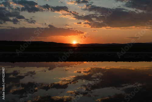 Calm water reflecting a dramatic sunset