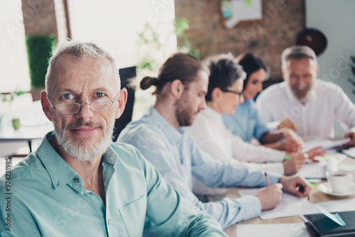 Photo of teamwork people working together mature man smile look camera comfortable modern office loft room interior indoors workspace