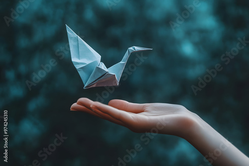 Hand holding an origami paper plane photo