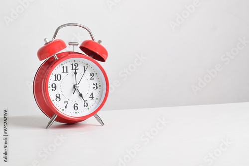 Red alarm clock set at five o'clock on table isolated on white background close-up with clipping path photo