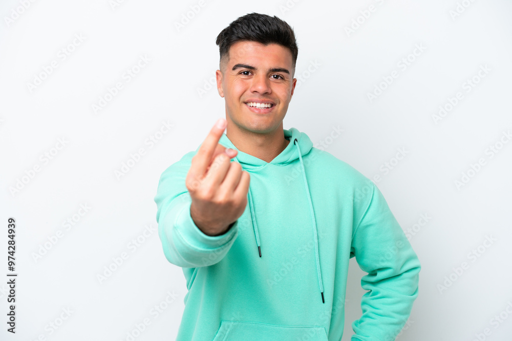 Young caucasian handsome man isolated on white background doing coming gesture Young caucasian handsome man isolated on white background doing coming gesture