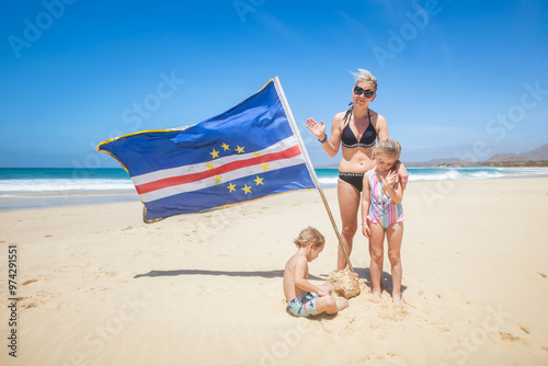 Mum with their children on Santa Monica beach on Boa Vista island with Cape Verde flag