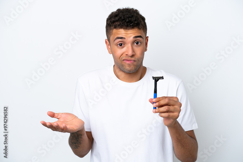 Bild auf Leinwand Young Brazilian man shaving his beard isolated on white background making doubts