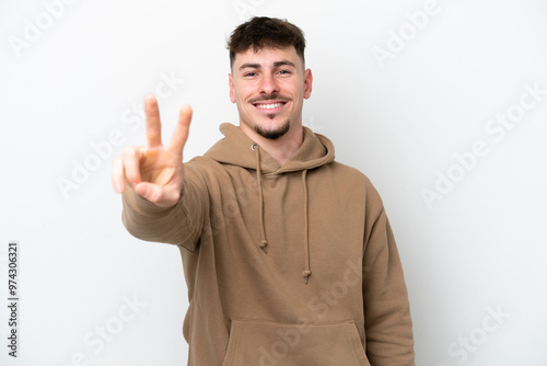 Young caucasian handsome man isolated on white background smiling and showing victory sign