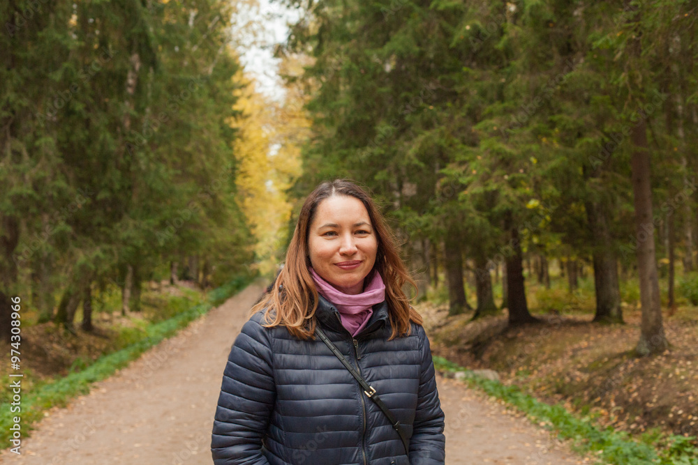 Autumn woman walking in park outdoor on nature background, portrait
