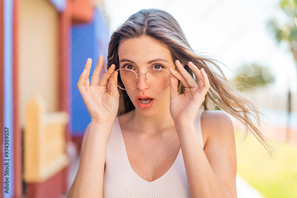Young pretty woman at outdoors With glasses and surprised expression Young pretty woman at outdoors With glasses and surprised expression