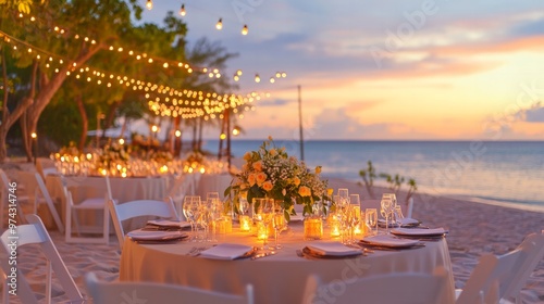 A romantic sunset beach wedding reception with tables set up on the sand, lit by candles and surrounded by the sound of the waves.