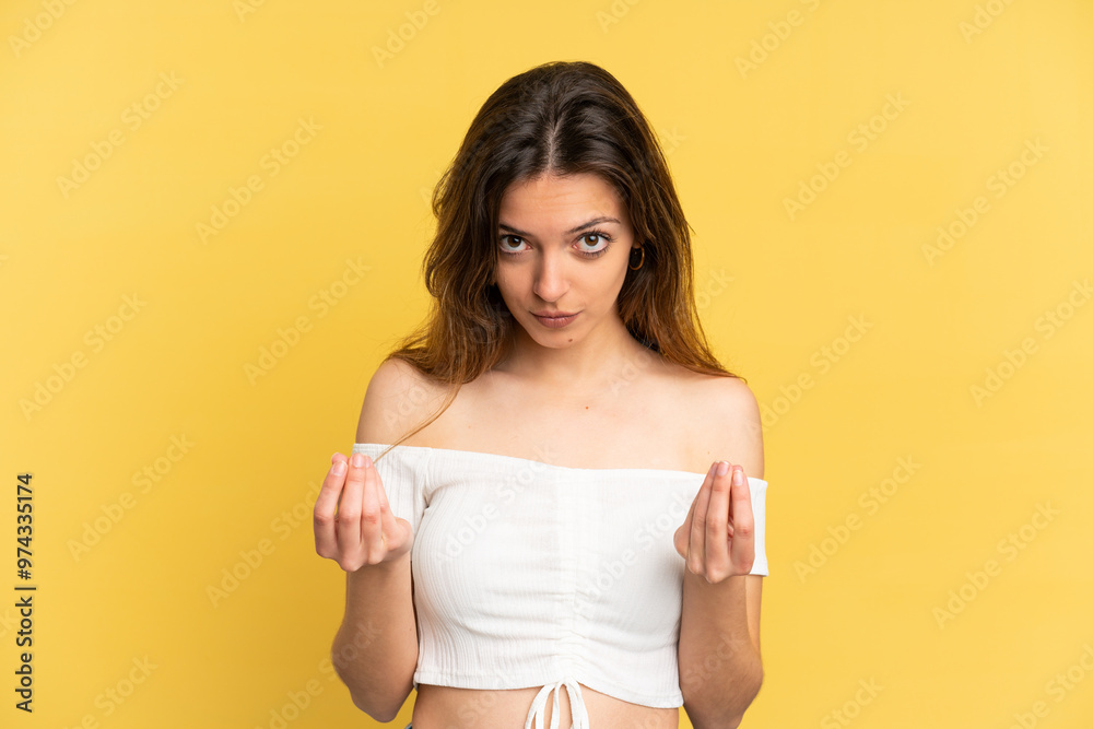 Young caucasian woman isolated on yellow background making money gesture but is ruined Young caucasian woman isolated on yellow background making money gesture but is ruined