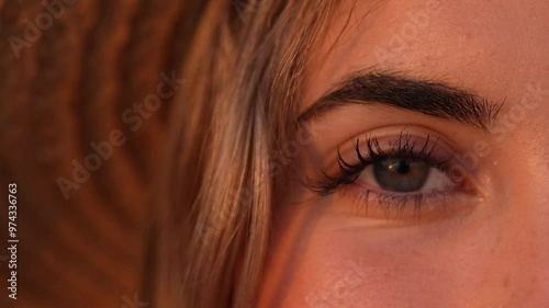 Portrait of one happy young beautiful woman smiling opening big blue and green eyes. Female girl at the beach close up face looking camera
