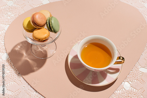 A cup of tea and fruit flavored macarons.