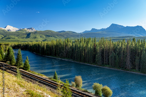 Bow River flows through forest and railway track. Storm Mountain in the background. Castle Cliff Viewpoint, Bow Valley Parkway, Banff National Park, Canadian Rockies, Alberta, Canada. photo