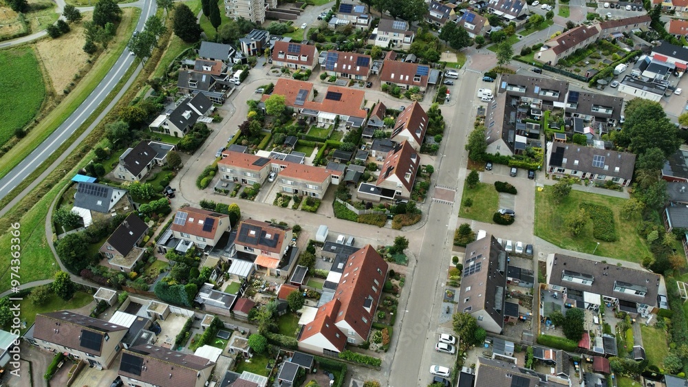 Naklejka premium Aerial shot of houses with solar panels on roof in a street in a residential area neighborhood in Steenwijk, Overijssel, The Netherlands.