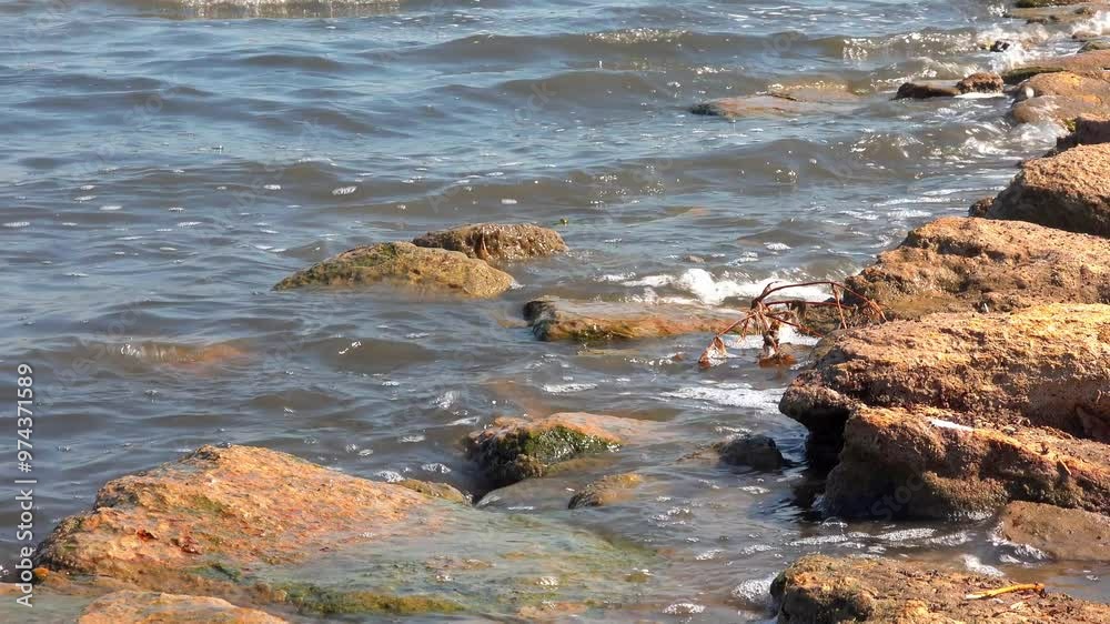 Windy weather, waves crashing on rocks and foaming in the salty hypersaline Kuyalnik estuary, Ukraine Windy weather, waves crashing on rocks and foaming in the salty hypersaline Kuyalnik estuary, Ukraine