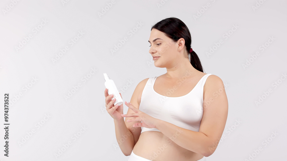 Young, beautiful brunette with curvy figure using skincare products on a white background. Perfect for promoting skincare, emphasizing confidence and beauty with your products. Young, beautiful brunette with curvy figure using skincare products on a white background. Perfect for promoting skincare, emphasizing confidence and beauty with your products.