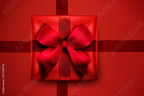 Rotes Geschenk mit Schleife vor Rotem Hintergrund